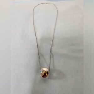 Silver pendant with gold star on the front and an arrow on the back.